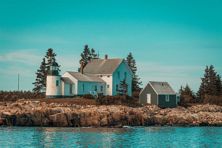 White lighthouse and keeper&rsquo;s house on a rocky Maine island